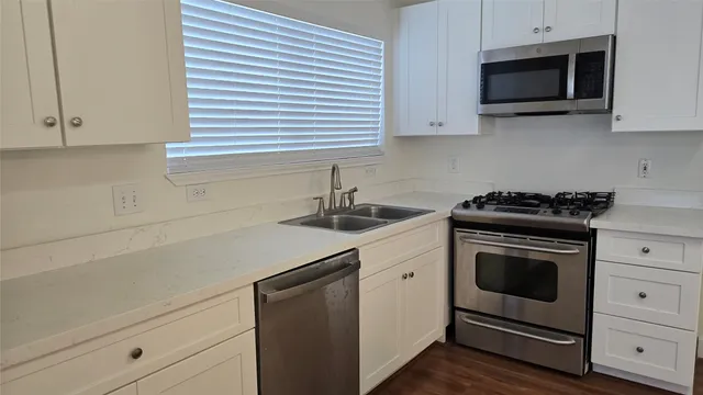a kitchen with stainless steel appliances white cabinets and a stove