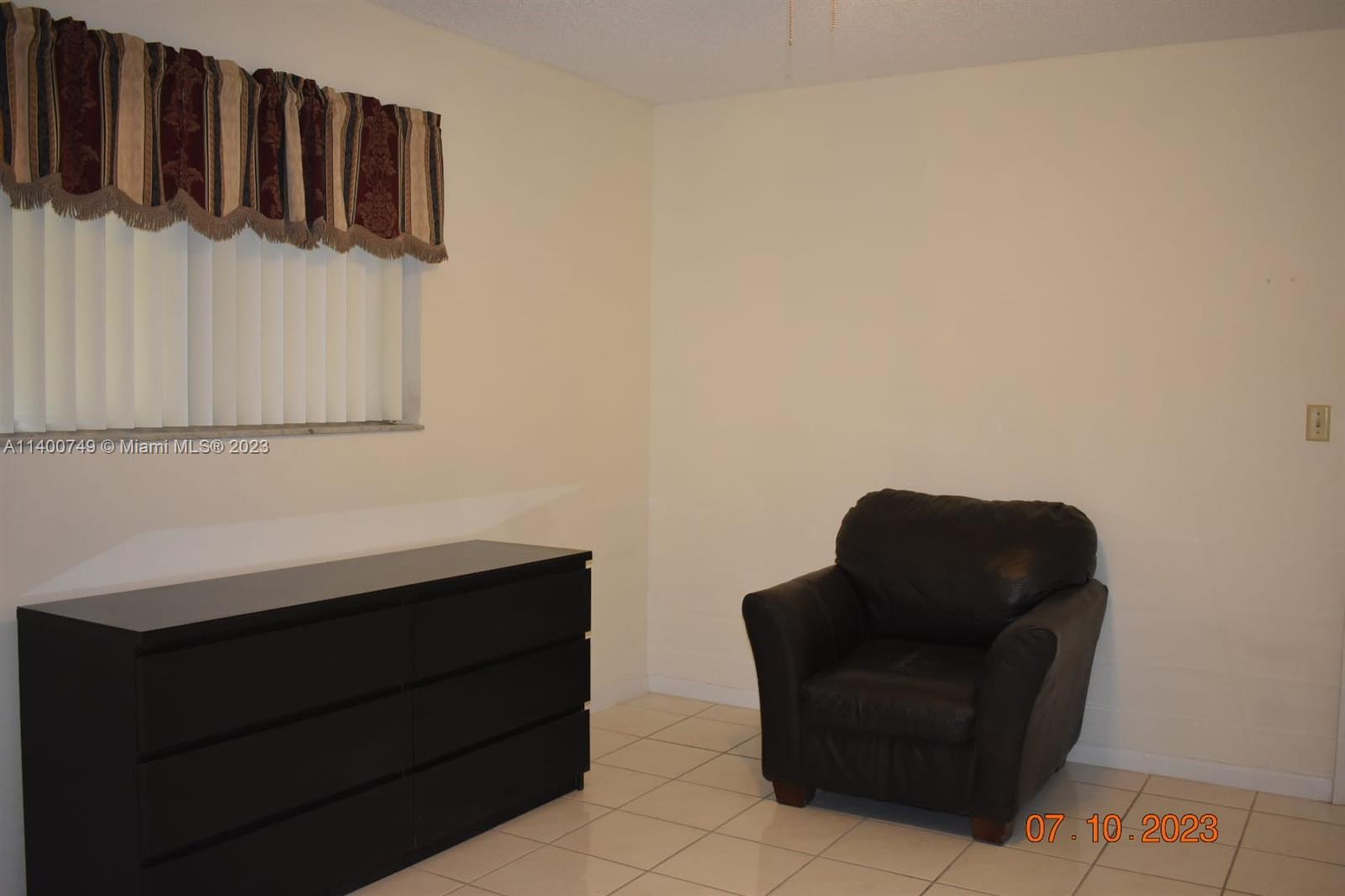 3501 Inverrary Drive, Unit 204 Lauderhill, FL 33319 - Photo 11 of 18 a living room with furniture and a chair