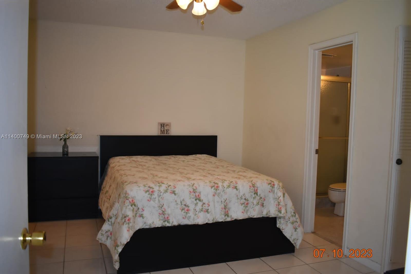 3501 Inverrary Drive, Unit 204 Lauderhill, FL 33319 - Photo 8 of 18 a bedroom with a bed and a lamp on dresser