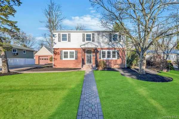 a front view of a house with a garden and trees