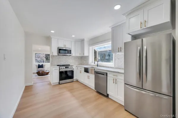 a kitchen with a refrigerator a stove top oven a sink and cabinets