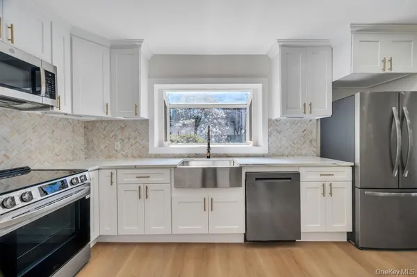 a kitchen with white cabinets and stainless steel appliances
