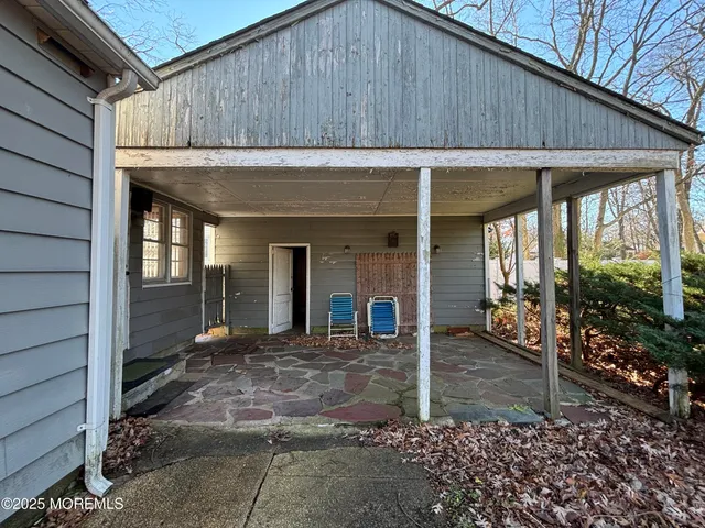 a backyard of a house with large trees and outdoor seating