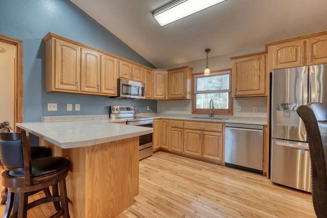 1995 River Hill Road Murphy, NC 28906 - Photo 16 of 68 a kitchen with stainless steel appliances granite countertop a refrigerator a sink dishwasher a stove and white countertops with wooden floor