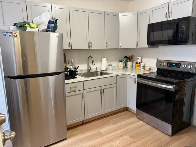 a kitchen with stainless steel appliances a refrigerator stove top oven and sink
