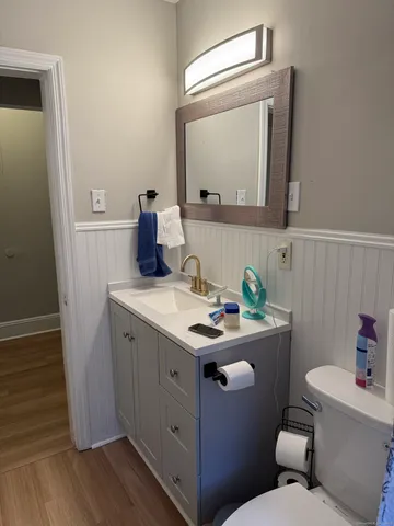 a bathroom with a granite countertop toilet sink and mirror