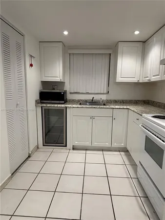 a kitchen with a stove sink and cabinets