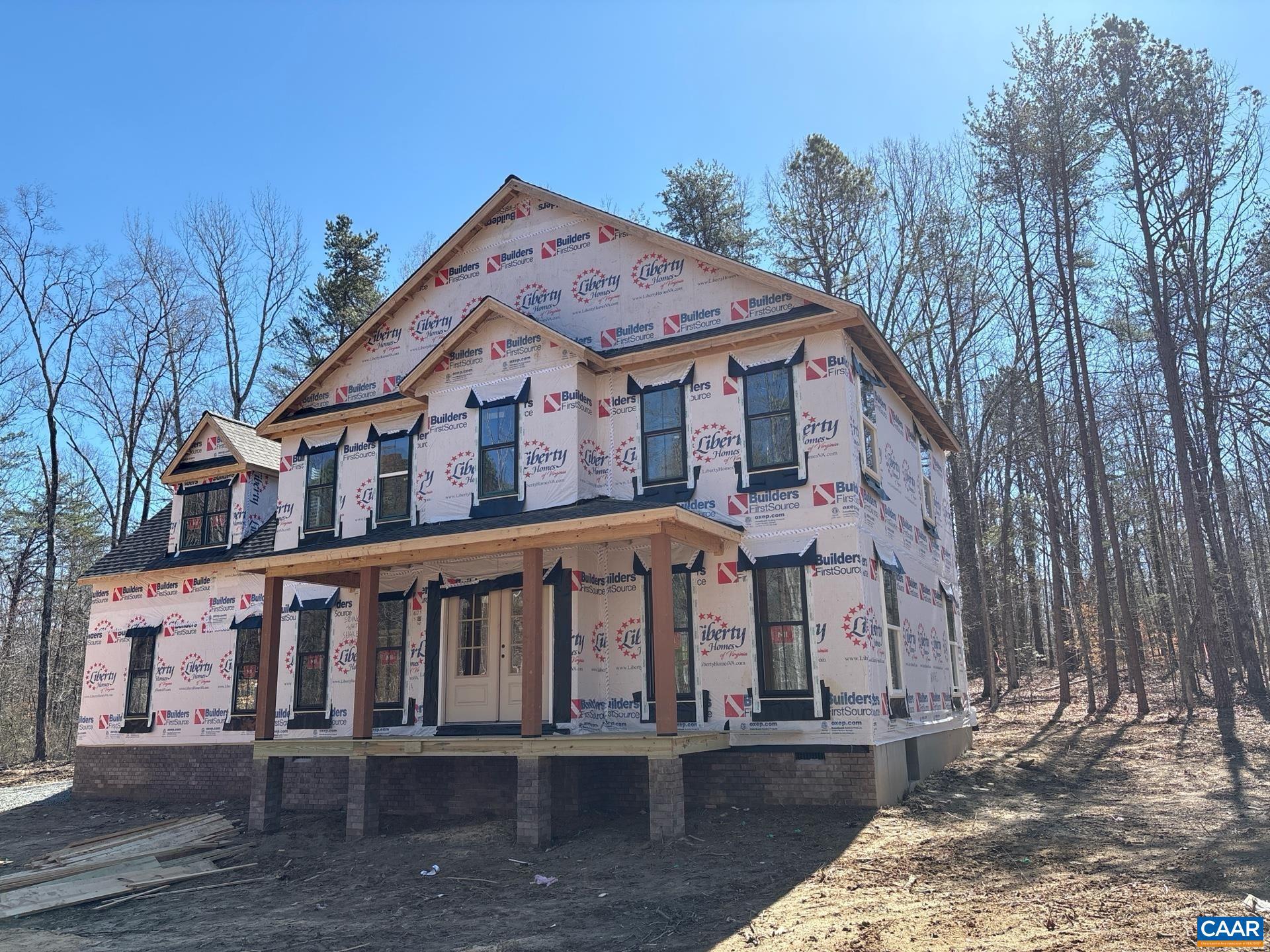 11675 West Jack Jouett Road Zion Crossroads, VA 22942 - Photo 2 of 33 a view of a white house with large windows and a small yard with wooden fence