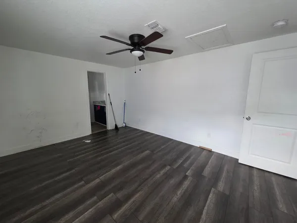 a view of empty room with wooden floor