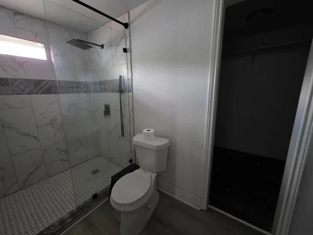 a bathroom with a toilet and a shower