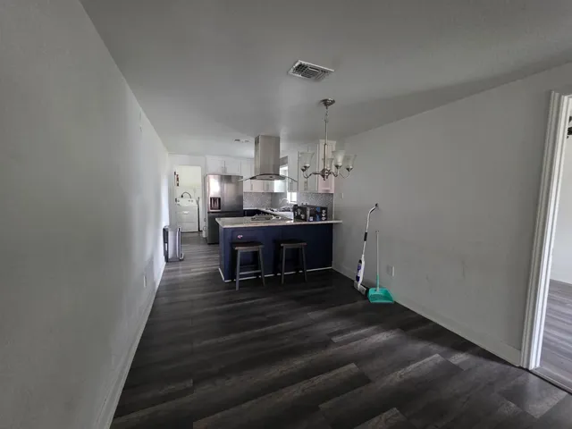 a living room with kitchen island furniture and a chandelier
