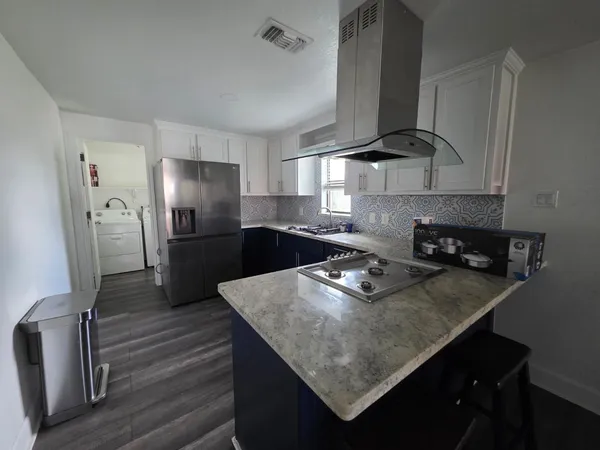 a kitchen with stainless steel appliances granite countertop a sink a stove and a refrigerator