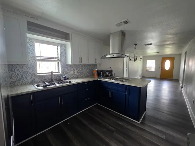 a kitchen with stainless steel appliances granite countertop a stove a sink and a window