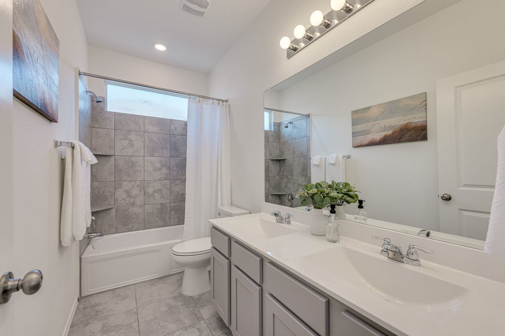 1107 Winifred Drive Austin, TX 78748 - Photo 25 of 40 Upstairs bath with double vanity and stylish tile surround.