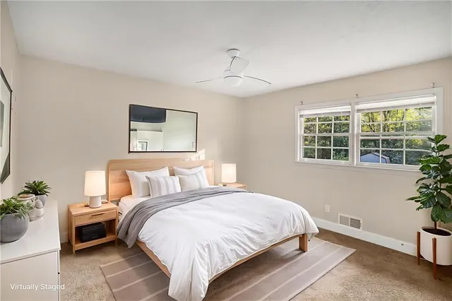 a bedroom with a bed and a potted plant