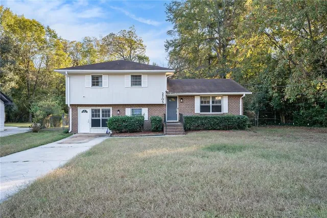 a front view of a house with a garden and yard