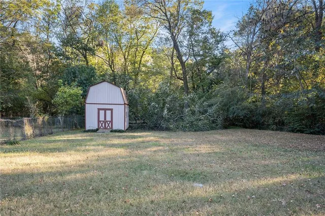 a view of a house with a yard and large trees