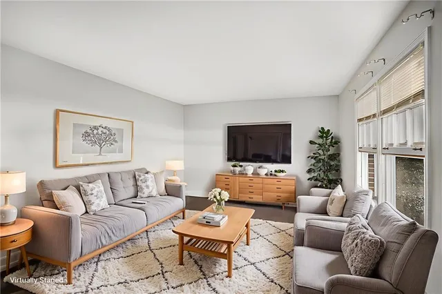 a living room with furniture a flat screen tv and a fireplace