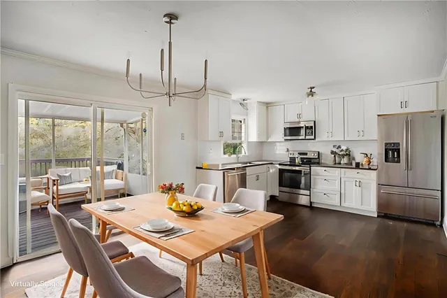 a kitchen with stainless steel appliances wooden floor dining table and chairs
