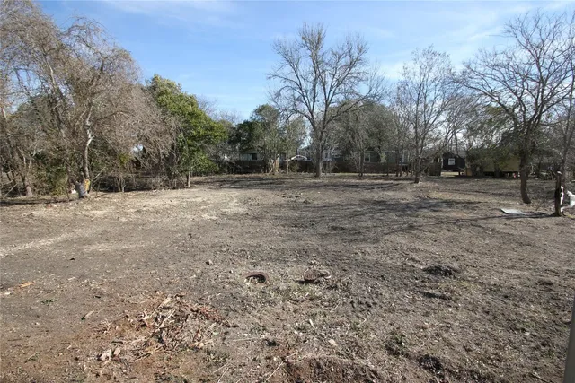 a view of dirt yard with trees