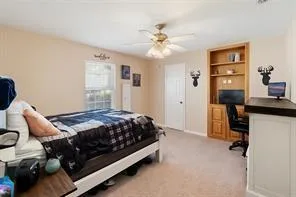 a bedroom with a large bed and ceiling fan