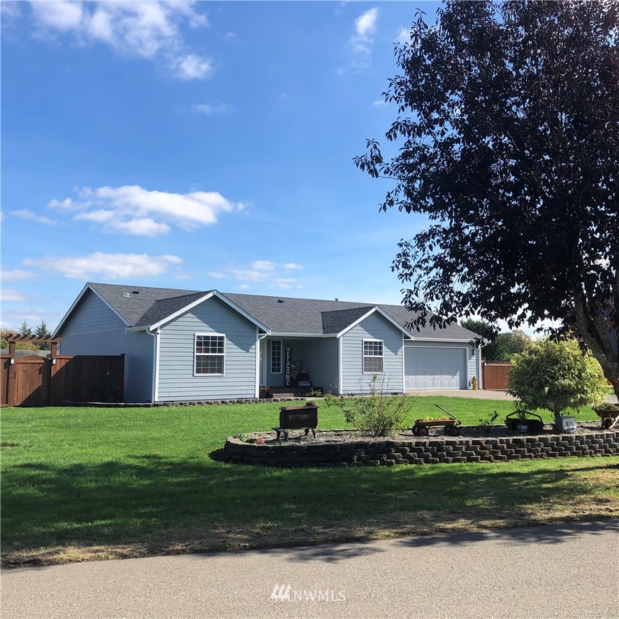 9131 Applegate Loop Southwest Rochester, WA 98579 - Photo 1 of 32 a front view of a house with a garden and trees