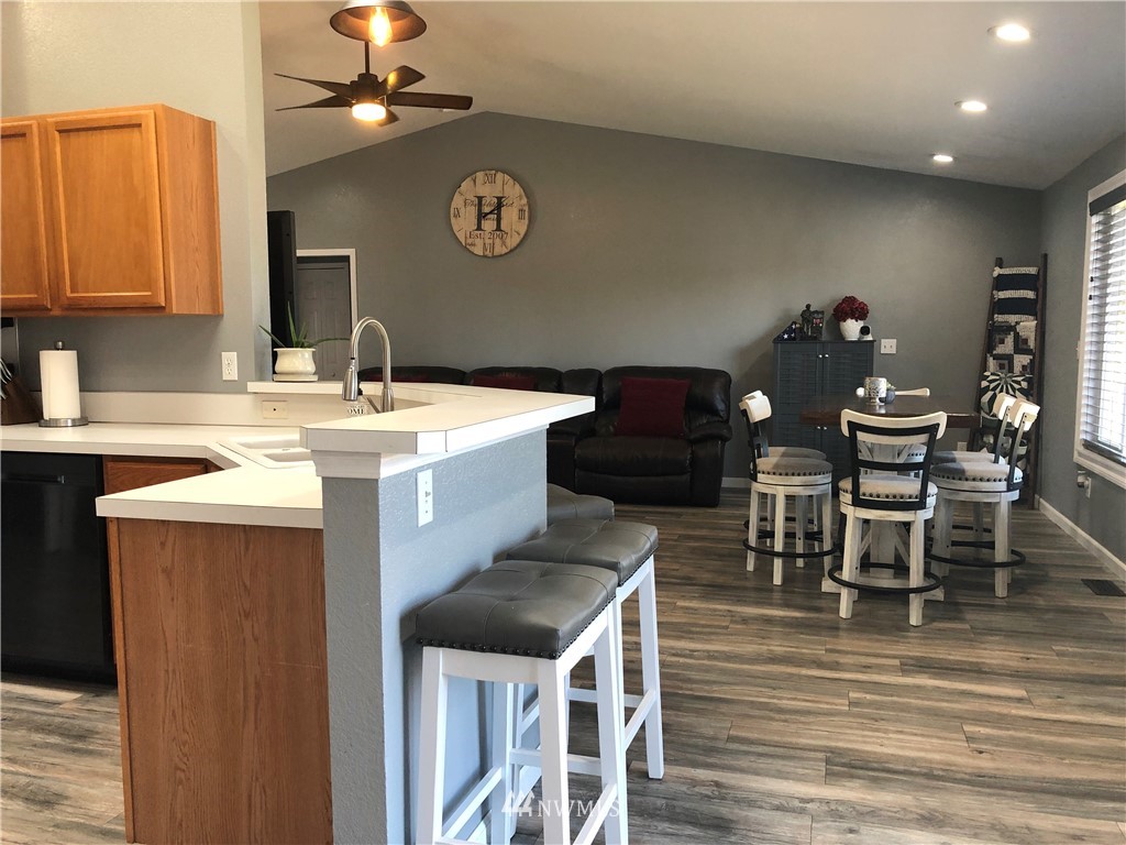 9131 Applegate Loop Southwest Rochester, WA 98579 - Photo 11 of 32 a kitchen with a dining table chairs and refrigerator