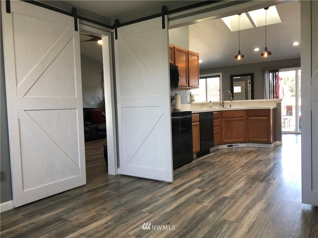 9131 Applegate Loop Southwest Rochester, WA 98579 - Photo 13 of 32 a kitchen with a dining table chairs and refrigerator