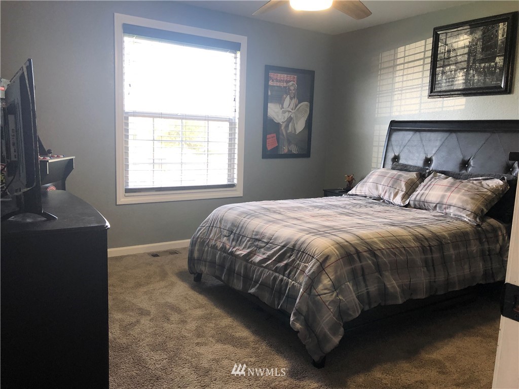 9131 Applegate Loop Southwest Rochester, WA 98579 - Photo 19 of 32 a bedroom with a bed and a chandelier