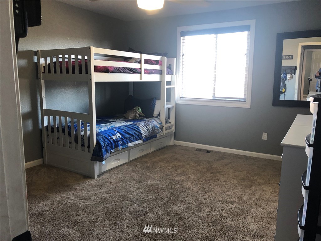 9131 Applegate Loop Southwest Rochester, WA 98579 - Photo 21 of 32 a bedroom with a bed and a window