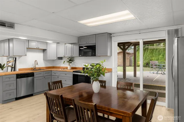 a kitchen with stainless steel appliances granite countertop a dining table chairs and granite counter tops
