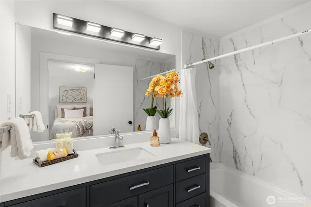 a en suite bathroom with a double vanity sink a mirror and shower