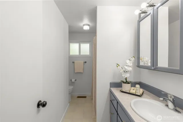 a bathroom with a sink and mirror with toilet