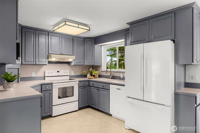 a kitchen with cabinets a refrigerator and a sink
