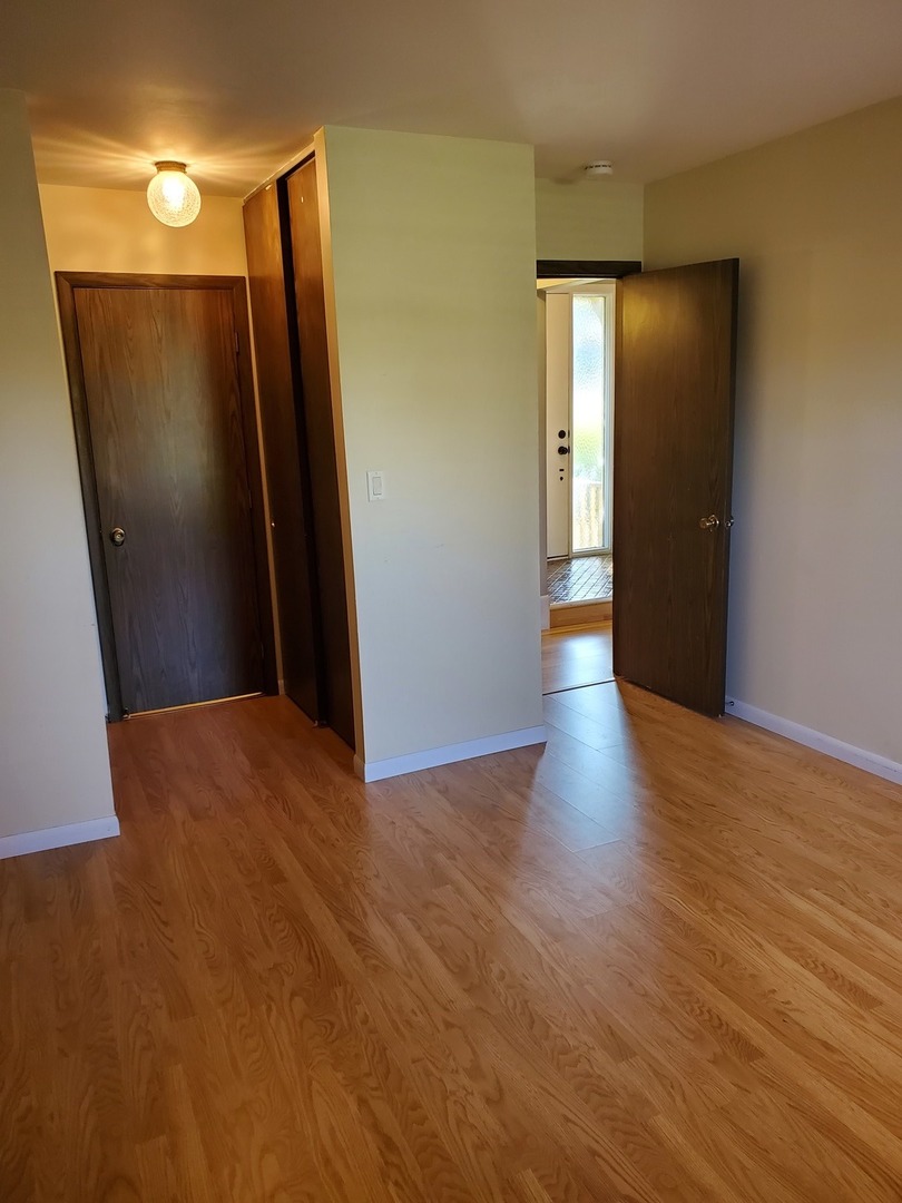 726 Chandler Road Gurnee, IL 60031 - Photo 13 of 43 a view of an empty room with wooden floor and a window