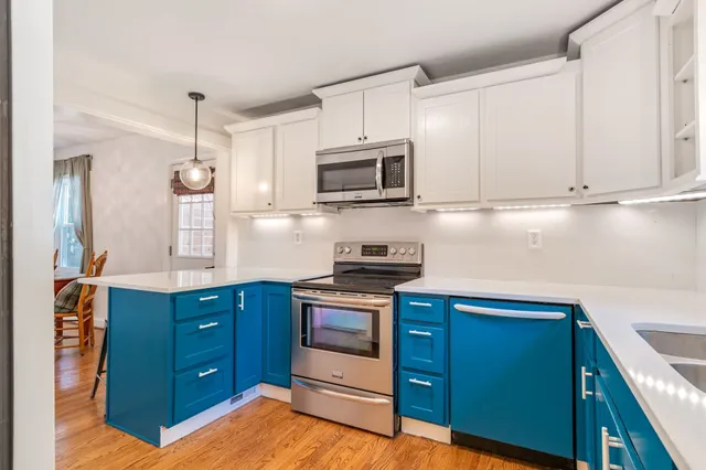 a kitchen with stainless steel appliances granite countertop a sink a stove and microwave