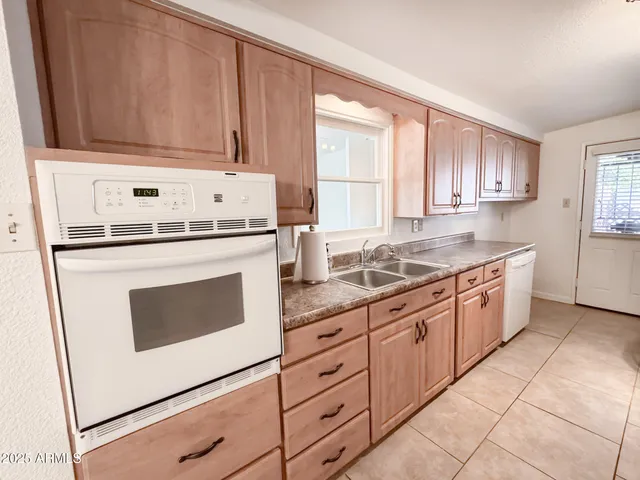 an empty room with windows and ceiling fan