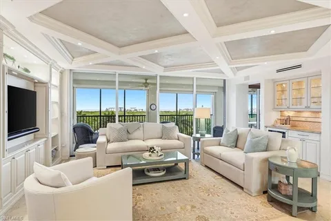 a living room with furniture a flat screen tv and a large window