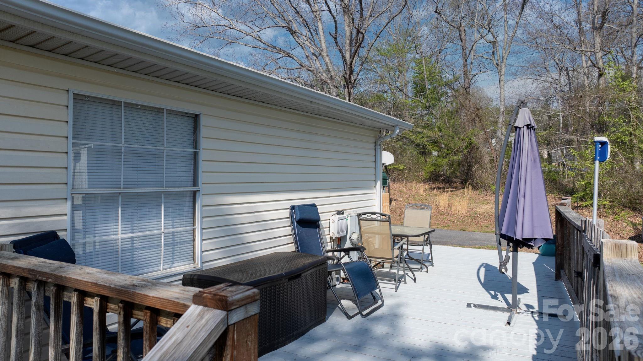 7911 Bailey Road Connelly Springs, NC 28612 - Photo 11 of 32 a view of a patio with table and chairs with wooden fence and plants