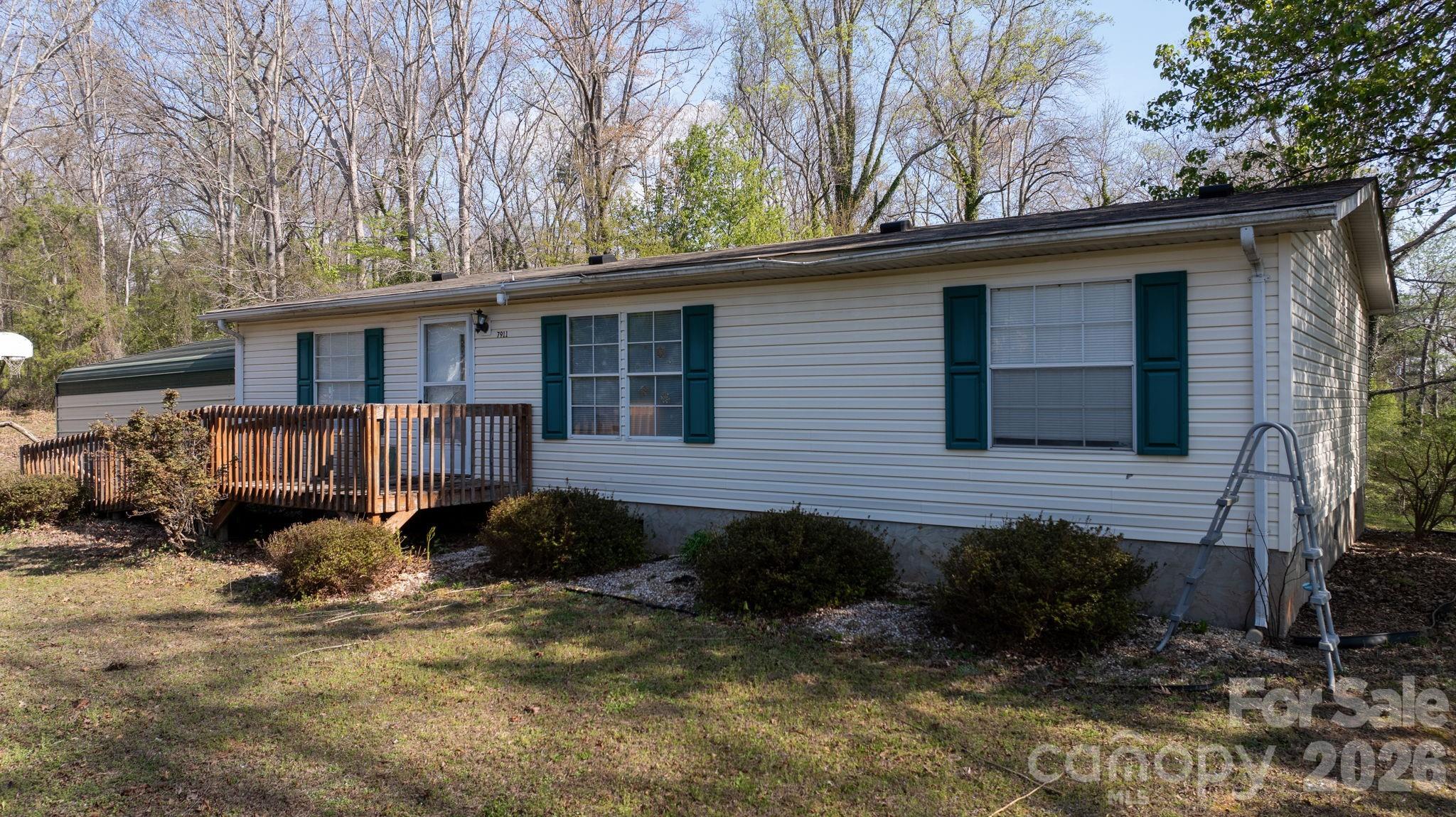 7911 Bailey Road Connelly Springs, NC 28612 - Photo 6 of 32 a backyard of a house with wooden fence and large trees