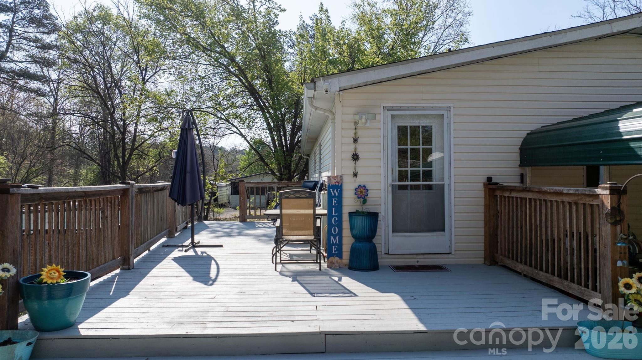 7911 Bailey Road Connelly Springs, NC 28612 - Photo 7 of 32 a view of a patio with table and chairs with wooden fence and floor