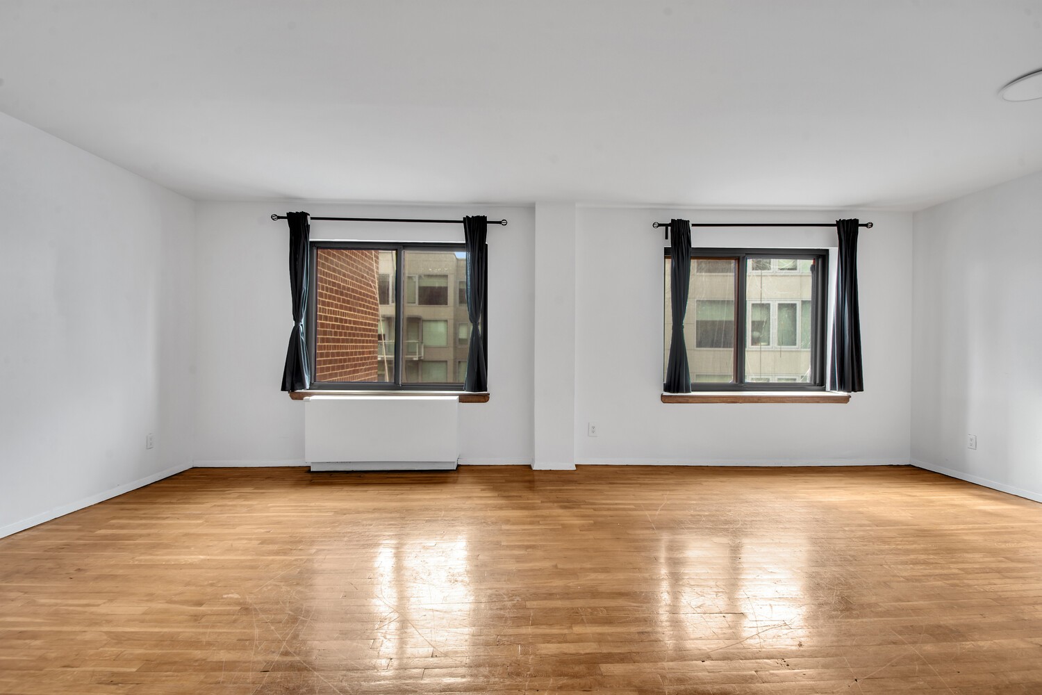414 West 54th Street, Unit 5B Manhattan, NY 10019 - Photo 3 of 12 a view of an empty room with window and wooden floor