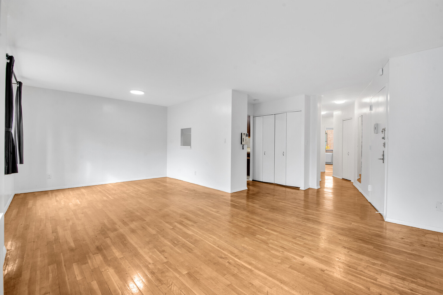 414 West 54th Street, Unit 5B Manhattan, NY 10019 - Photo 4 of 12 a view of an empty room with wooden floor and a window