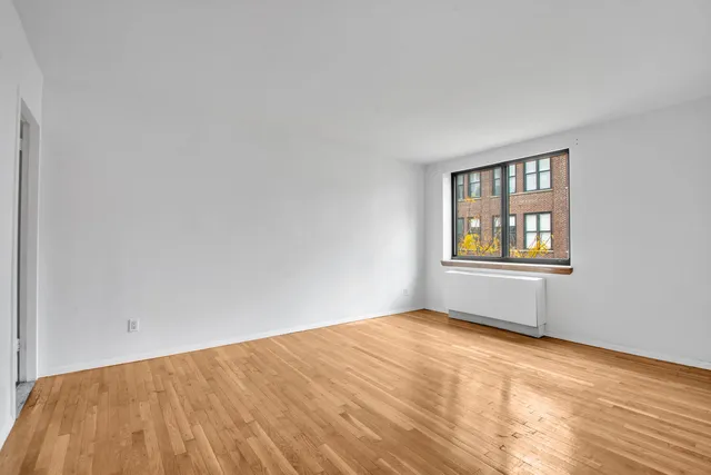 a view of an empty room and kitchen