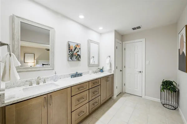 a spacious bathroom with a granite countertop double sink mirror and