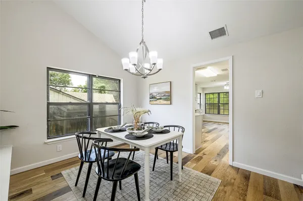 a dining room with furniture a rug and a chandelier