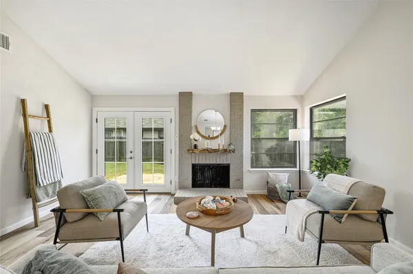 a living room with furniture a fireplace and a window