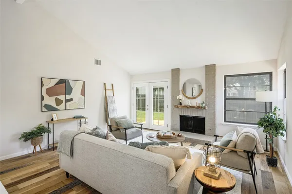 a living room with furniture fireplace and a large window