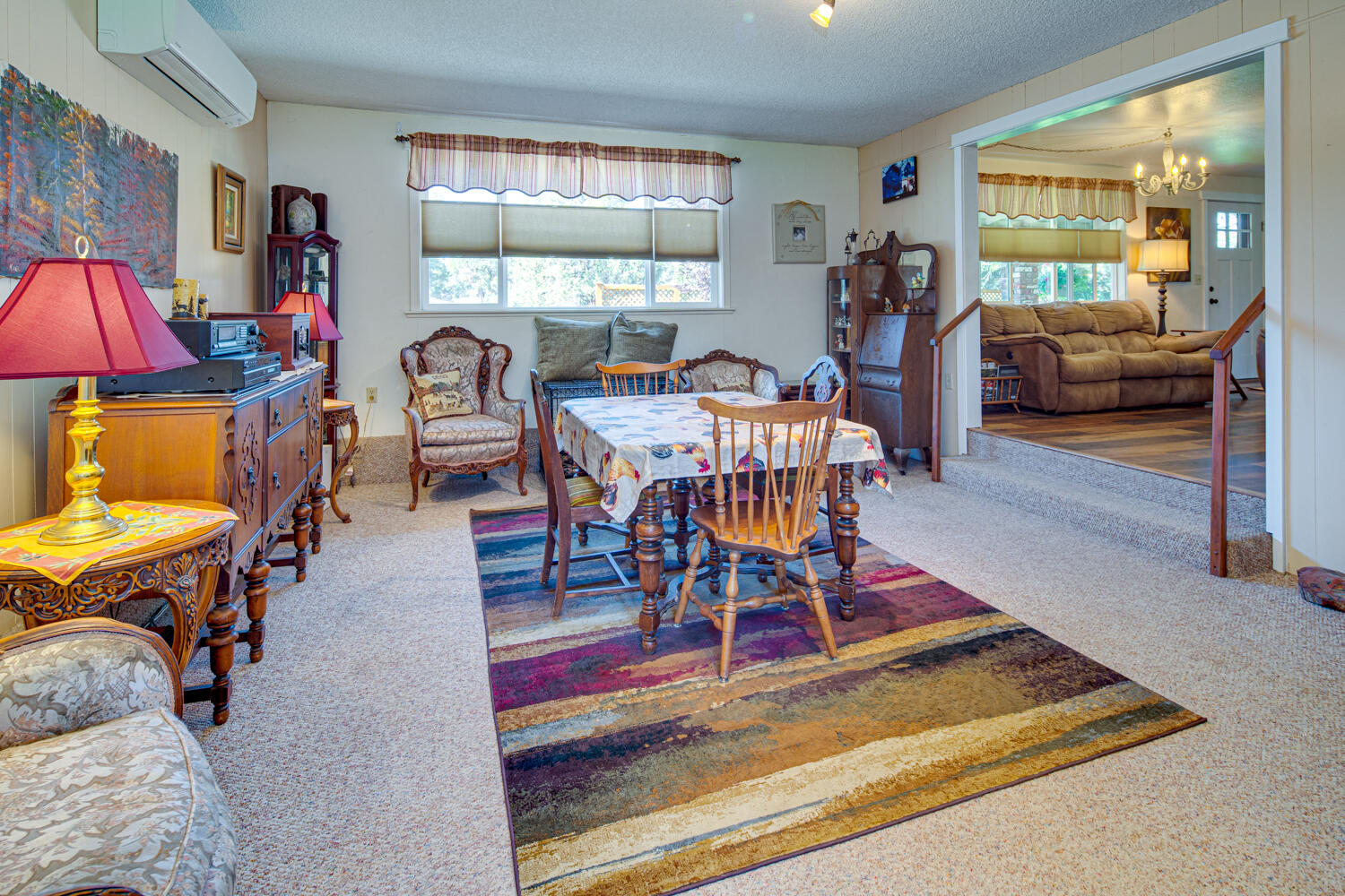 2218 Southwest 79th Street Redmond, OR 97756 - Photo 17 of 54 a dining room with furniture a rug a flat screen tv and a large window