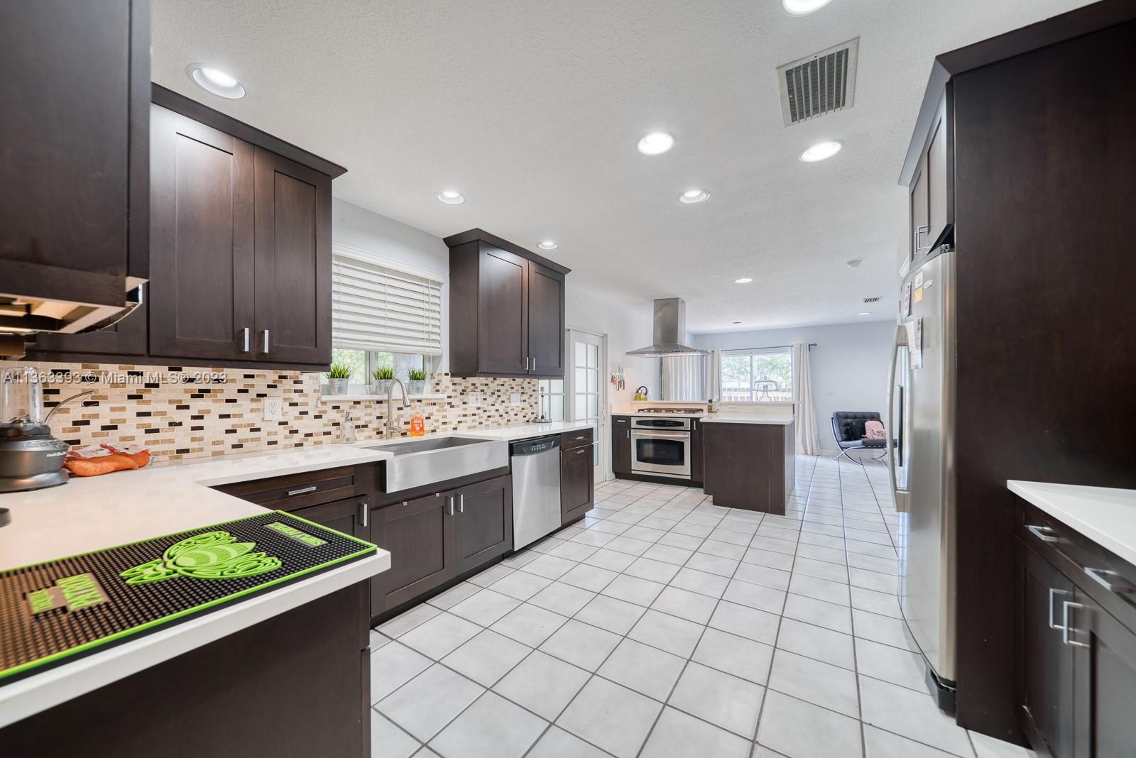 a large kitchen with a large counter top space appliances and cabinets